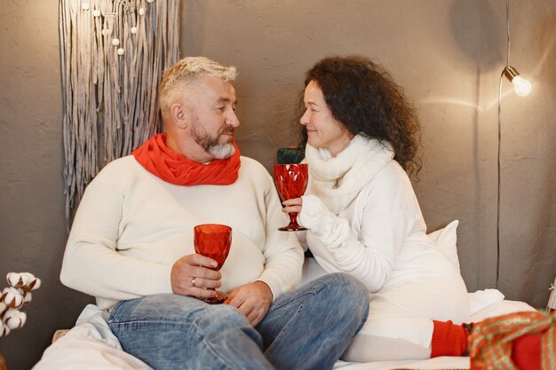 Age and people concept . Senior couple at home. Woman in a white knited sweater.