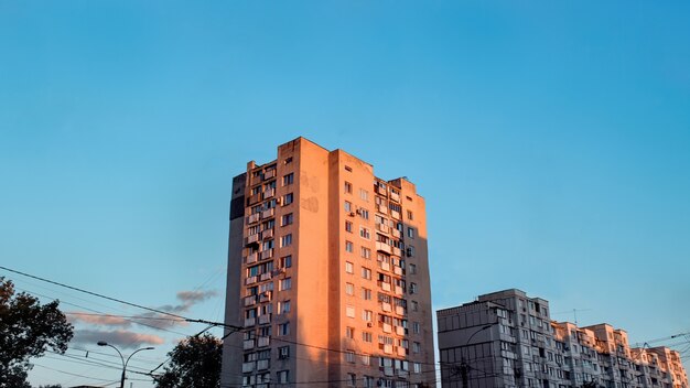 青い空と日没の老朽化した集合住宅