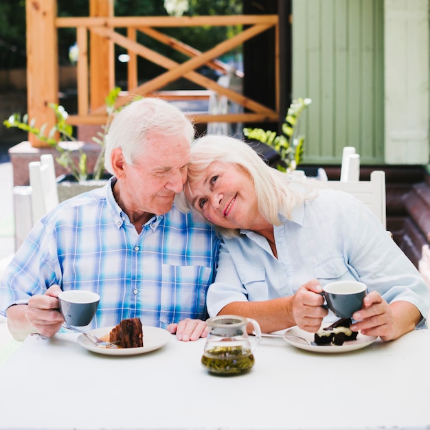 Free photo aged couple enjoying time together drinking tea outdoors