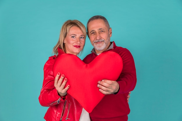 Free photo aged couple holding toy symbol of heart