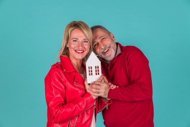 Aged couple showing toy house