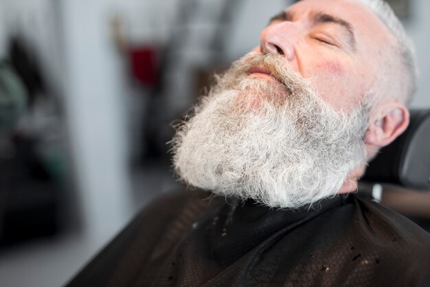 Aged gray haired man relaxing in salon