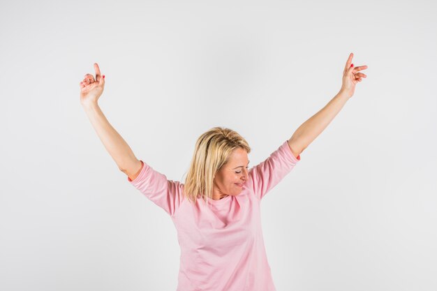 Aged happy lady in rose blouse with upped hands