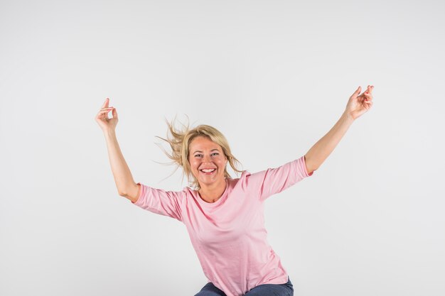 Aged happy woman in rose blouse with upped hands