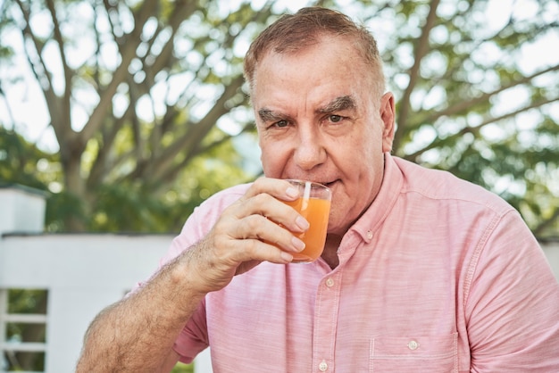 Foto gratuita uomo invecchiato che beve il succo