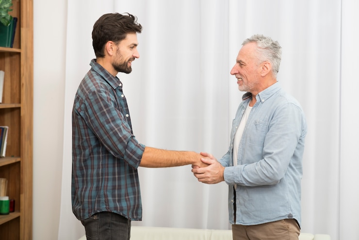 मुफ़्त फोटो aged man holding hands of young happy guy
