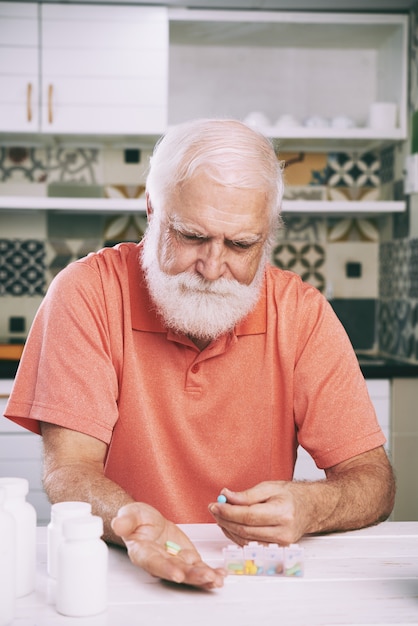 Free photo aged man taking pills