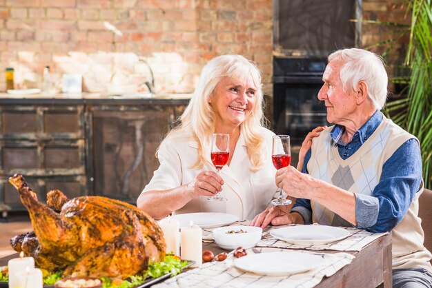 Aged man and woman with glasses near baked chicken