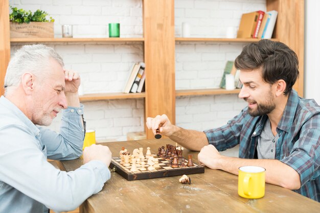 방에 테이블에서 체스 세 남자와 젊은 남자