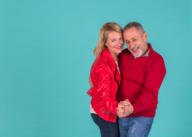 Aged positive man dancing with laughing woman