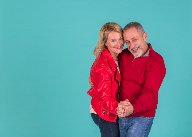 Aged positive man dancing with laughing woman