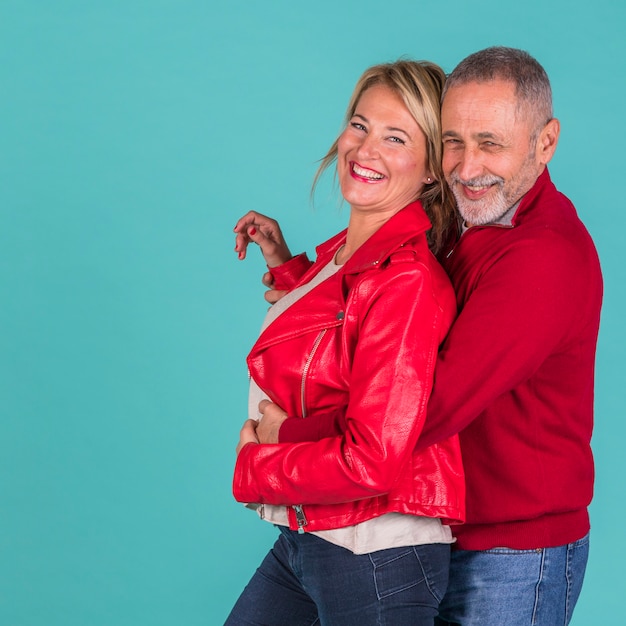 Aged positive man hugging from back laughing woman