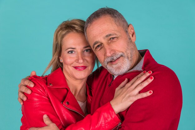 Aged positive man hugging with attractive woman