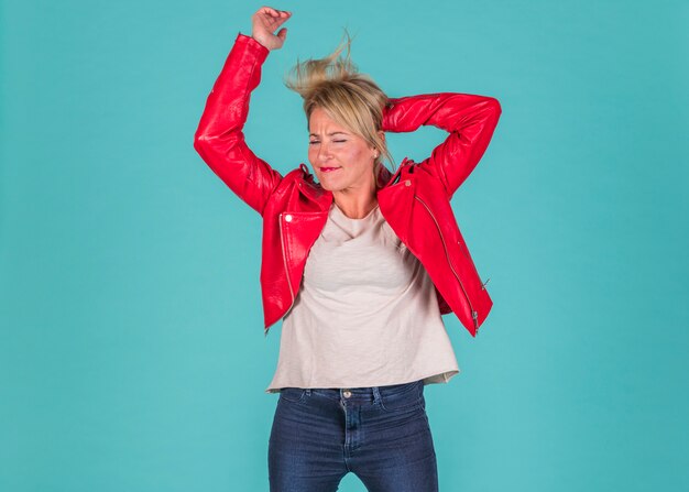 Aged woman in red wear with upped hands