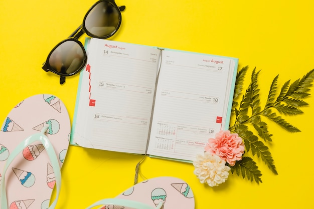 Foto gratuita agenda con occhiali da sole e flip-flop