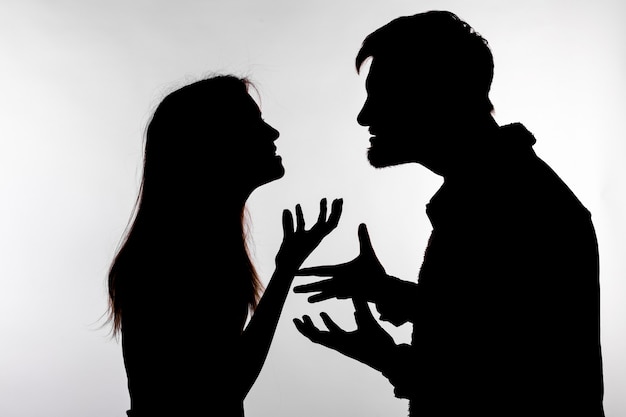 Aggression and abuse concept man and woman expressing domestic violence in studio silhouette