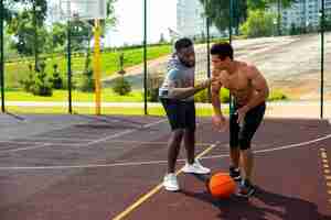 Free photo aggressive man playing  basketball long shot