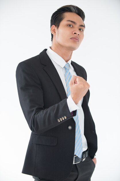 Aggressive young businessman threatening with fist