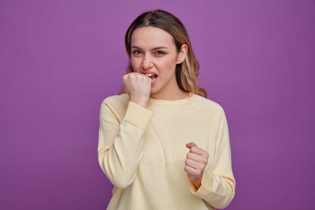 Aggressive young girl biting fist 