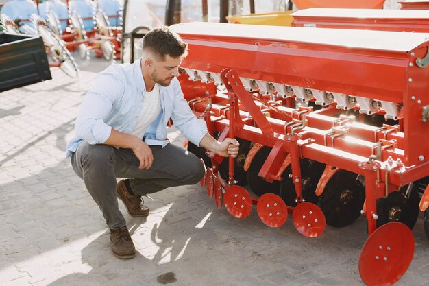 Agronomist choosing a new planter. Man at the outdoor ground of the shop. Agricultural machinery.