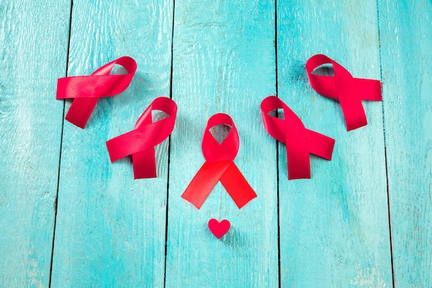 Aids awareness sign red ribbons on blue wooden background . world aids day concept. the health, help, care, support, hope, illness, healthcare concept