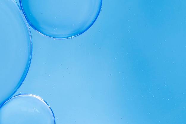Air bubbles in fluid on blue blurred background
