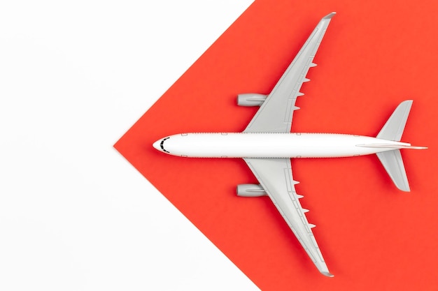 Free photo airplane on a red and white background flat lay travel concept