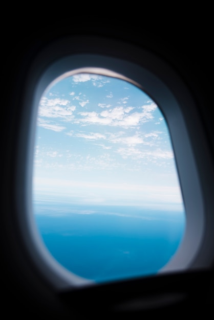 Airplane window with sky and sea lanscape