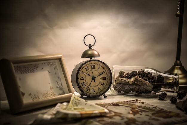 Alarm clock and bottle on the desktop