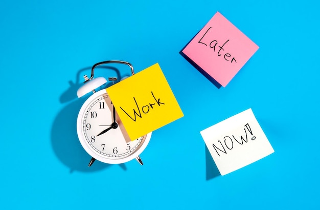 Free photo alarm clock and colorful paper reminders on a blue background top view