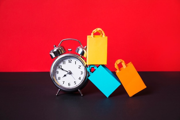 Alarm clock and colourful shopping packets
