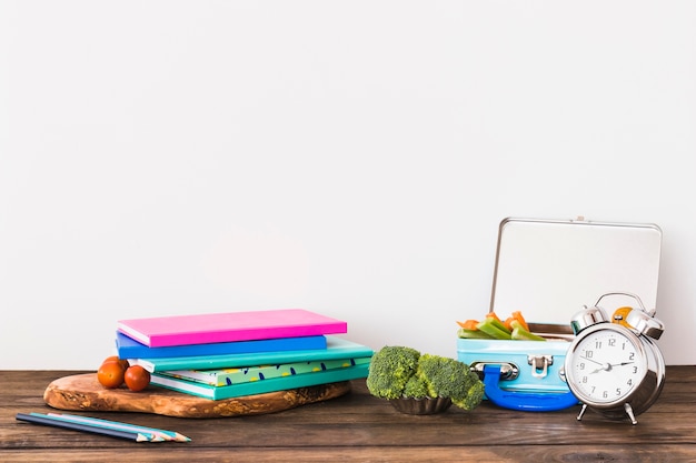 Alarm clock and lunchbox near stationery