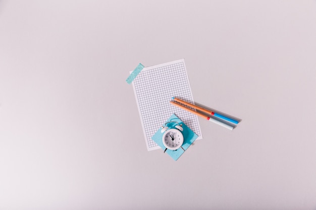 Alarm clock lying on sheet of paper glued to table