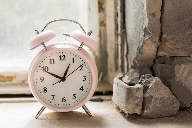 Free photo an alarm clock on old windowsill