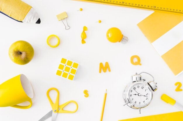 Alarm clock and yellow school supplies