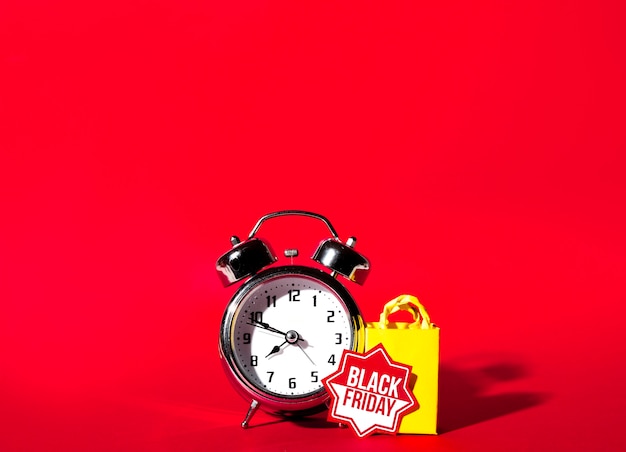 Free photo alarm clock and yellow shopping packet