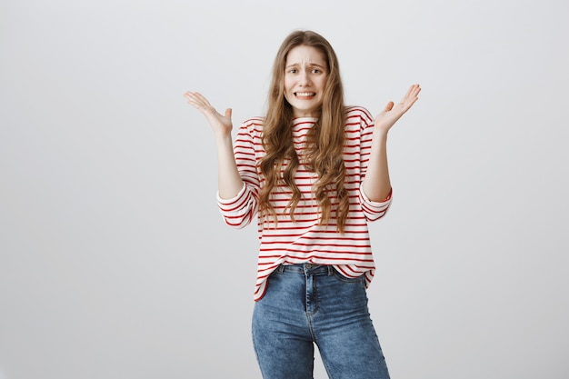 Alarmed young woman shaking hands and panicking