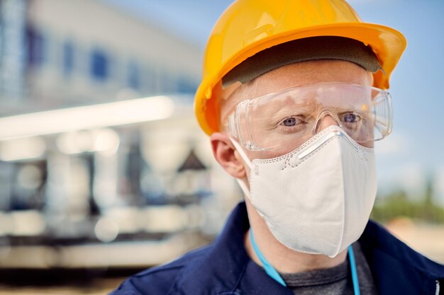 Albino construction worker wearing protective face mask at work