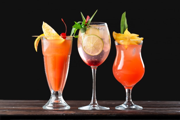 Алкогольные и безалкогольные коктейли на деревянный стол. летние холодные напитки