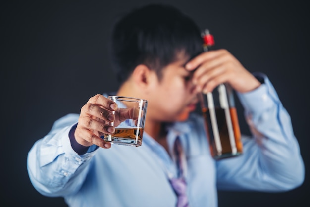 алкоголик азиатский мужчина пьет виски