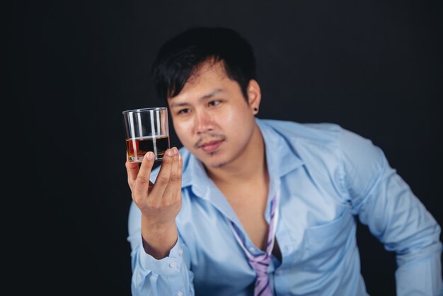 ウイスキーグラスを持つアルコールアジア男