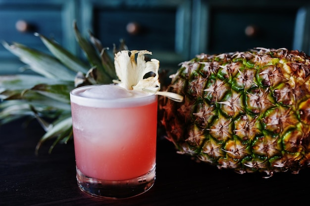 Foto gratuita cocktail alcolico con ananas al tavolo da bar