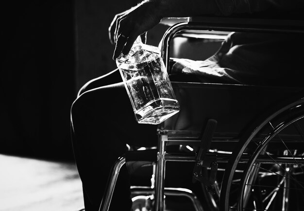 Алкогольный мужчина, сидящий в инвалидном кресле