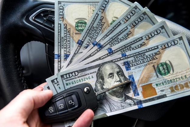 All for trip - auto dollar and car key in male's hand. finance concept Premium Photo