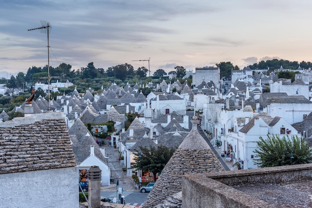 Alluring cityscape over the traditional roofs of the Trulli, original and old houses of this region, Apulia. Typical whitewashed buildings built with a dry stone walls and conical roofs.