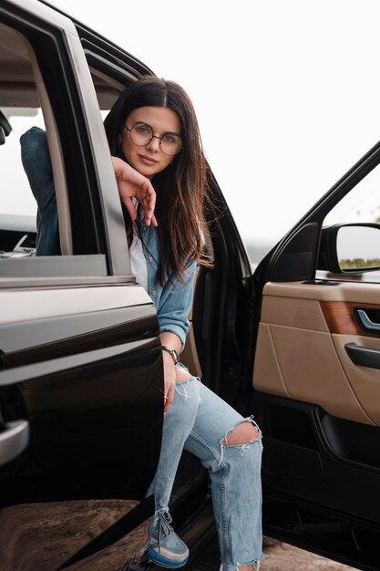Alluring woman with glasses traveling alone by car