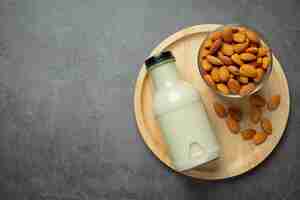 Free photo almond milk in bottle with almond on dark background