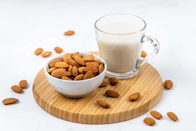 Premium Photo | Almond milk in a glass with almond on a wooden table