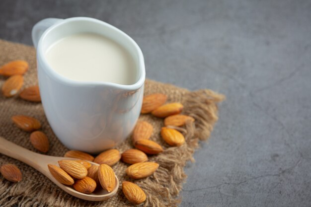 Almond milk with almond on dark background