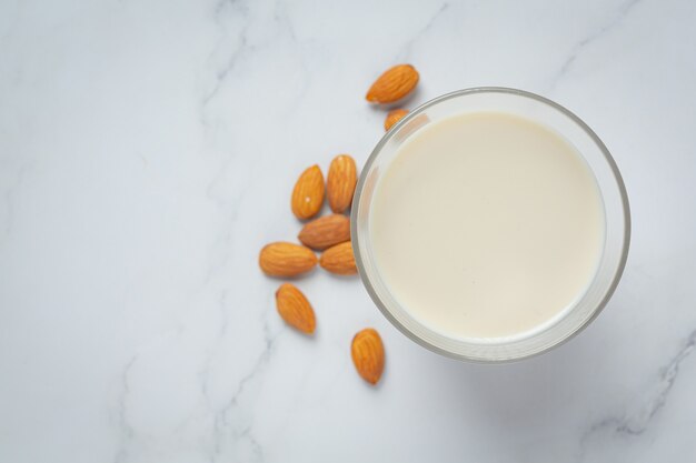 Almond milk with almond on marble background